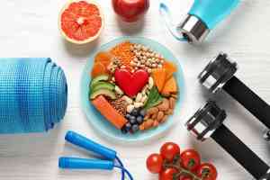 Bowl mit Obst darum angeordnet liegen Fitnessgeräte